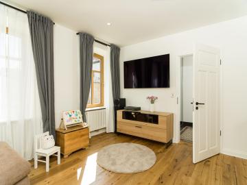 Wohnzimmer in Altbau mit Holzboden und Holzfenstern