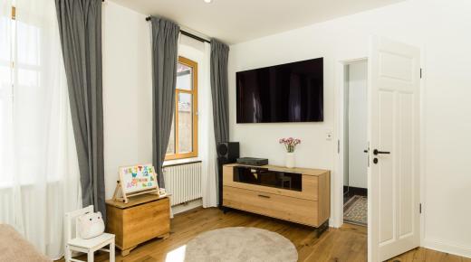 Wohnzimmer in Altbau mit Holzboden und Holzfenstern